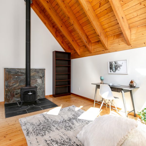 Cozy library/ loft area with a wood stove